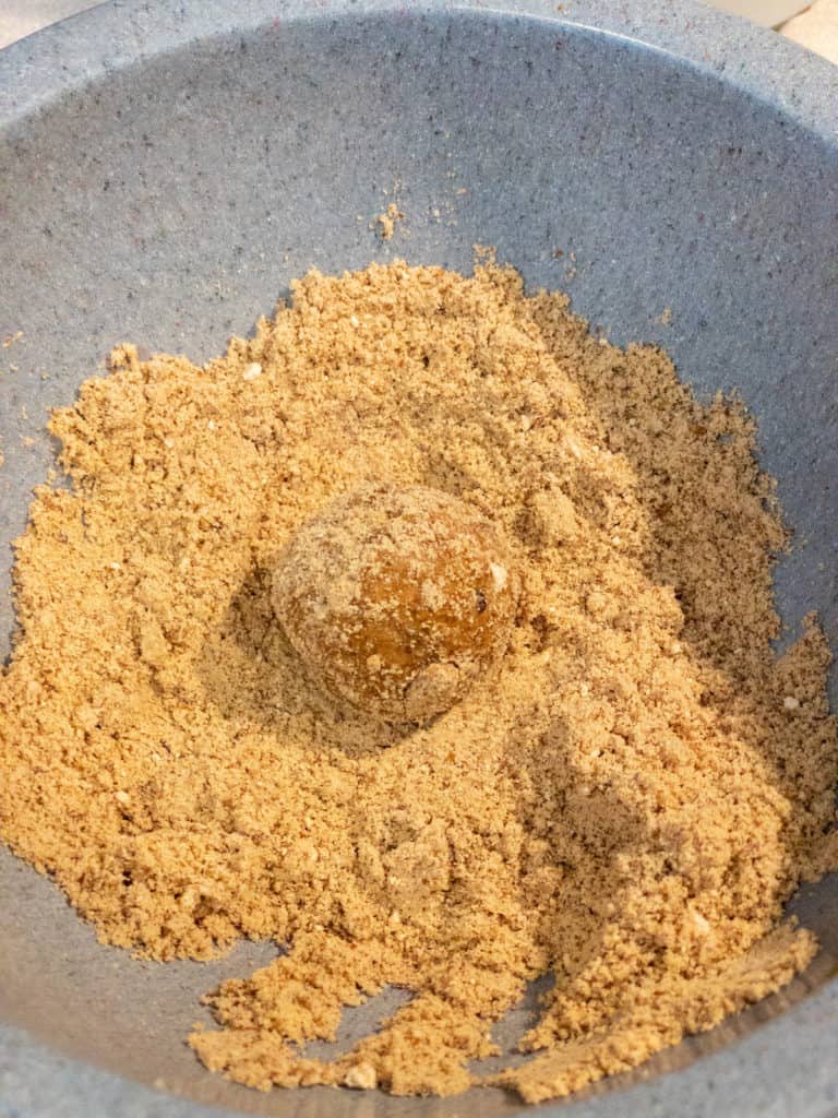 cake bite being rolled in maple cinnamon coating