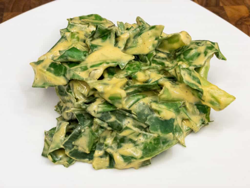 Cheezy ('Cheesy") Collard Greens Serving on White Plate