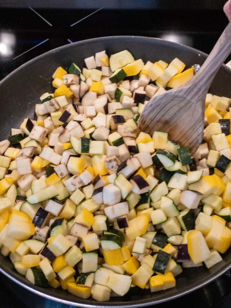 stirring easy ratatouille vegetables in pan