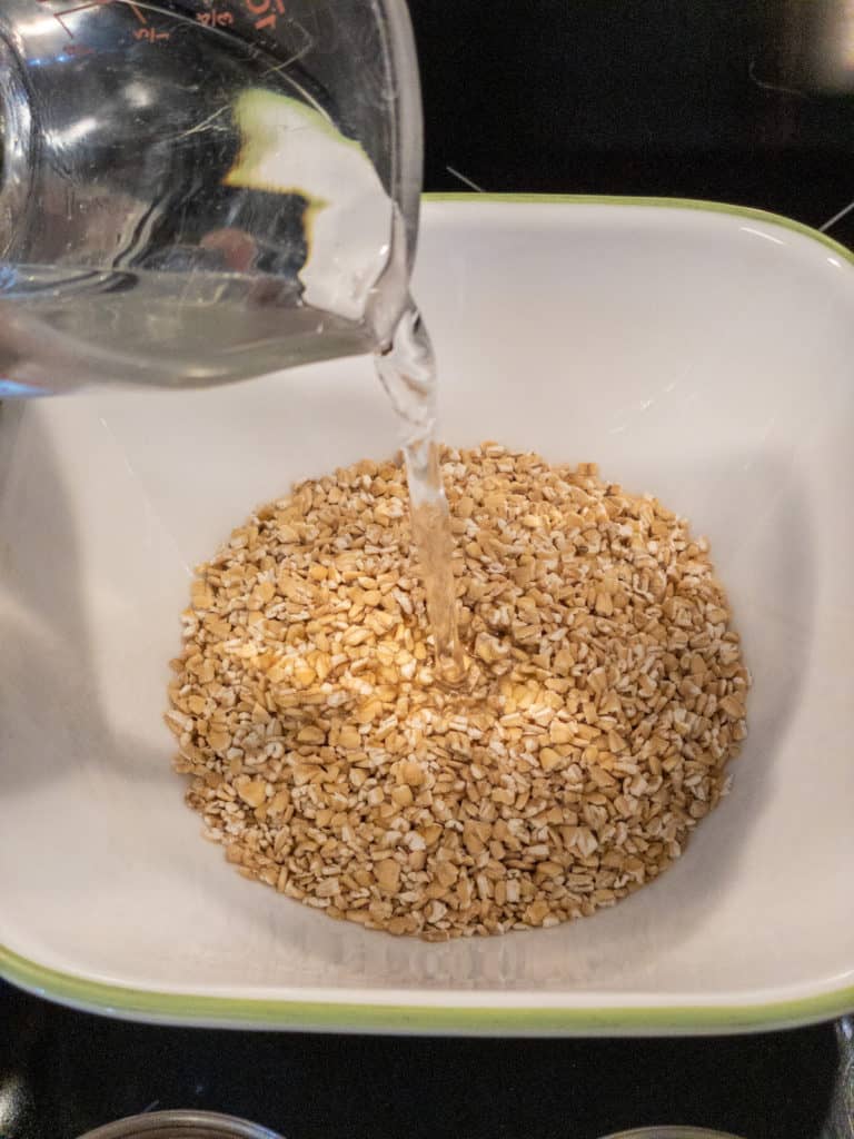 pouring water over steel cut oats in a bowl