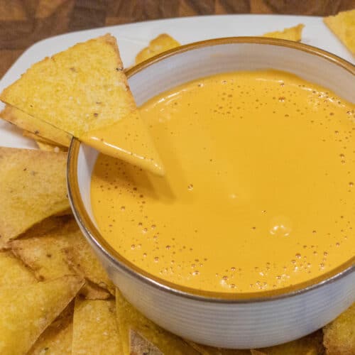 insane nacho cheeze cheese sauce in bowl and on a tortilla chip