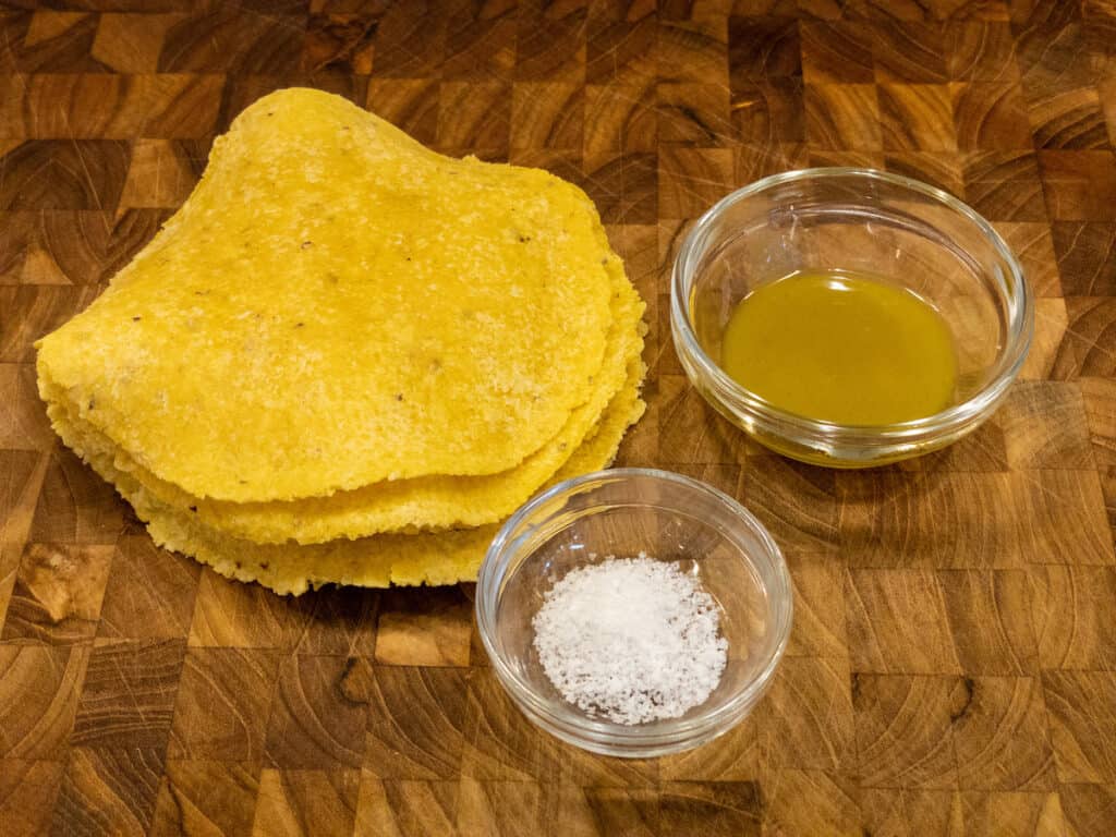 corn tortillas green pepper sauce and sea salt on cutting board