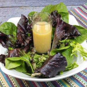 Salad Dressing in glass in bowl of greens