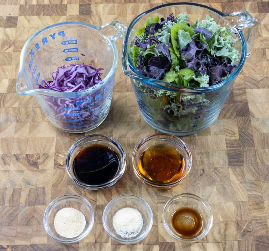 greens, red cabbage, soy sauce, maple syrup, liquid smoke, and spices on cutting board