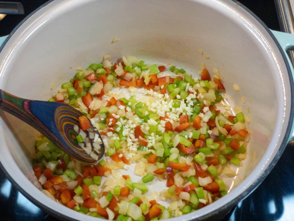 diced onion, celery, red pepper, and salt with added minced garlic in pot
