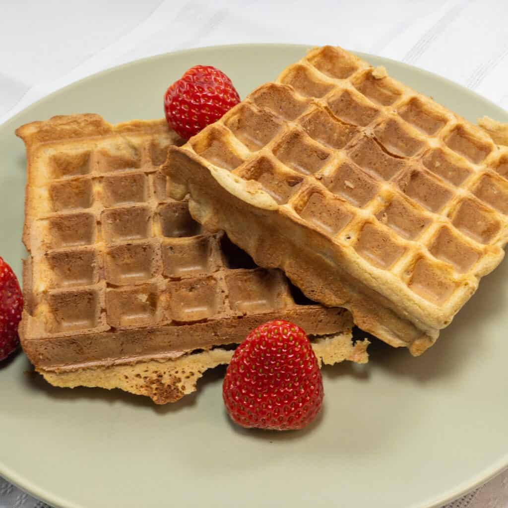 Millet Oat Blender Waffles on a green plate with strawberries